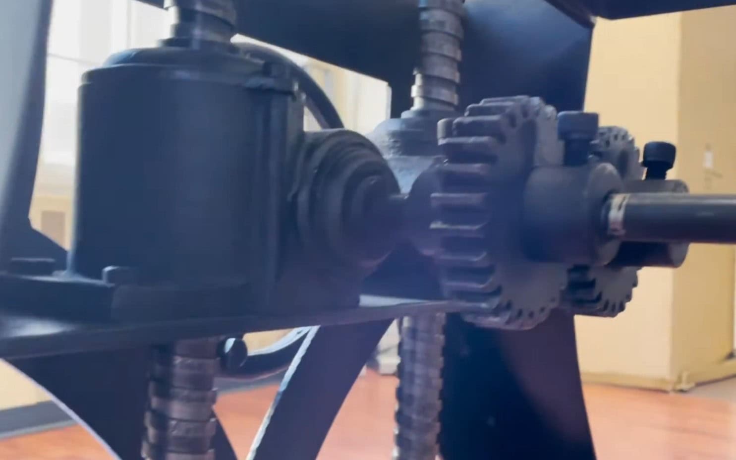Close-up of cast iron crank table base mechanism on Indian-manufactured knockoff — rough casting, poor gear mesh