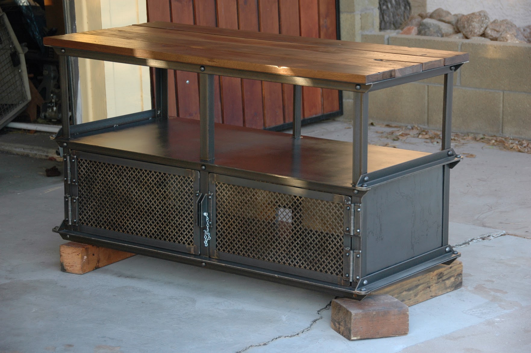The original Ellis Media Console photographed in Greg Hankerson's Phoenix garage, 2009 — hot-rolled steel frame with reclaimed wood top and wire mesh doors